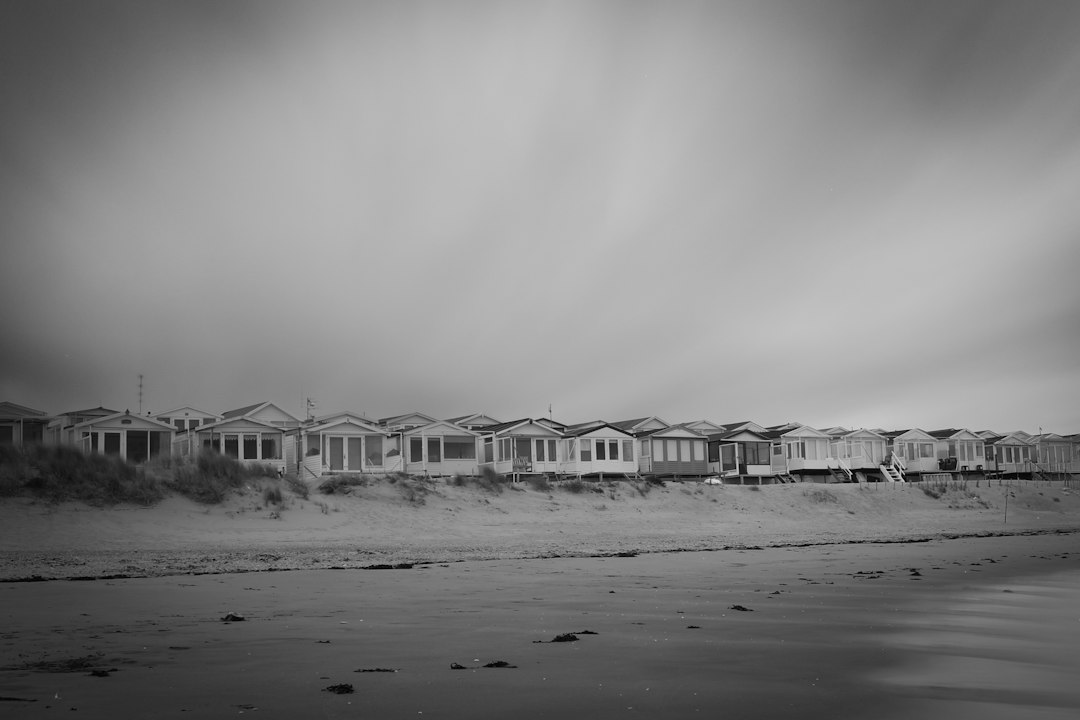 A black and white photo of houses on a beach