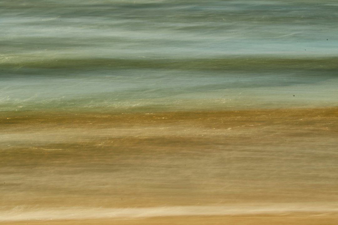 A blurry photo of the ocean and sand
